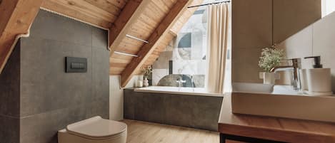 A modern bathroom with a wooden ceiling, a bathtub, and a toilet.