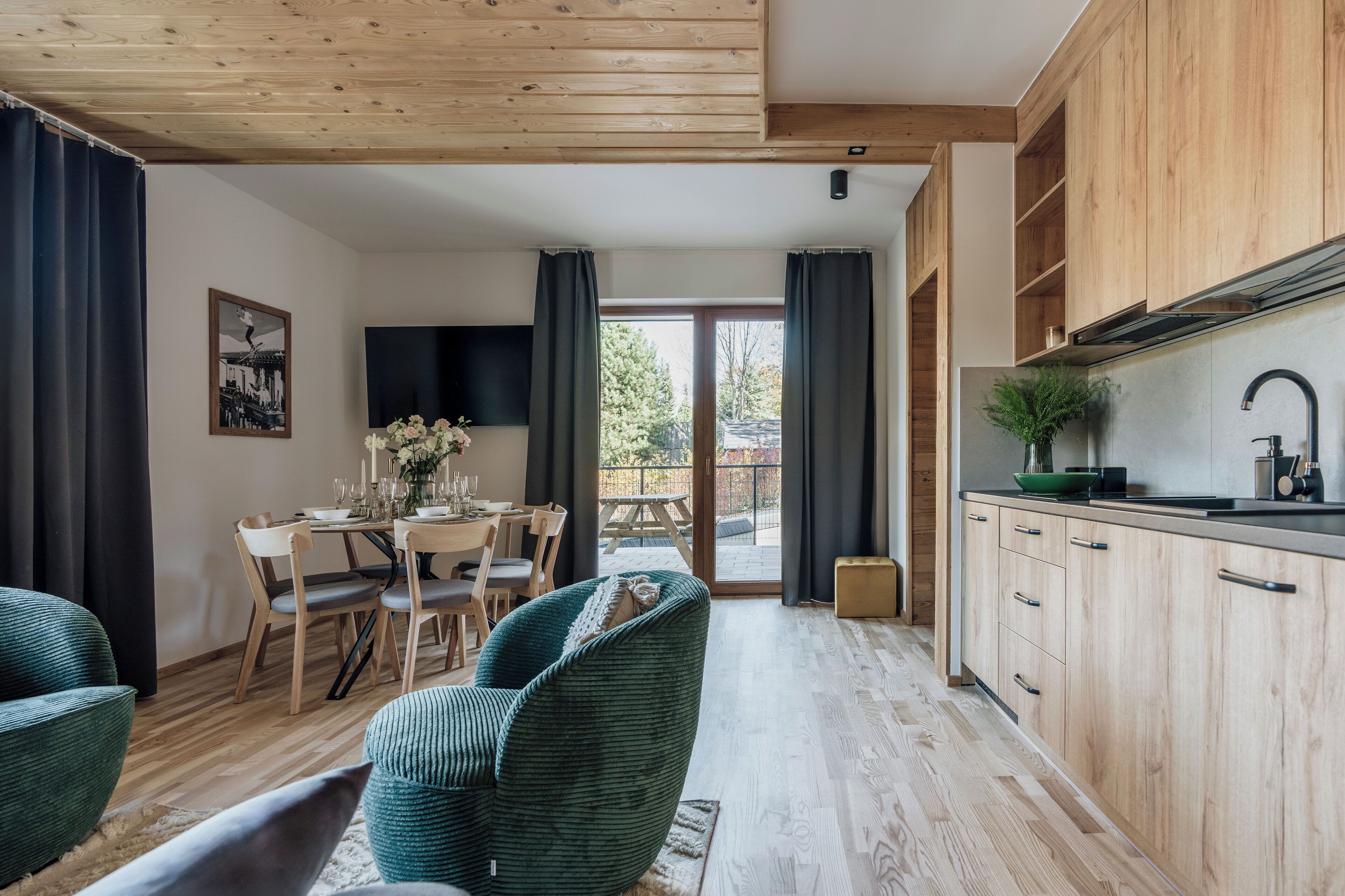 A modern kitchen with wooden cabinets and a dining area with a table and chairs.