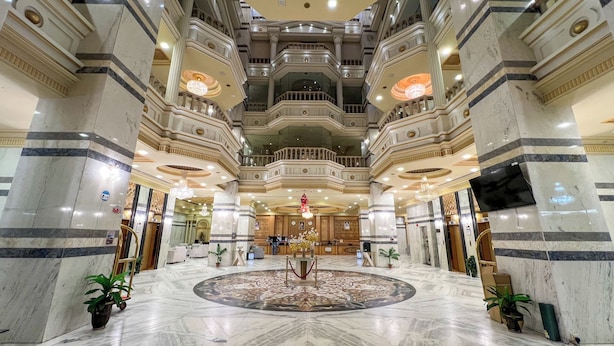 A grand lobby with marble floors, a central decorative fountain, and multiple balconies. - Rahaf Almashaer Hotel (Makkah)
