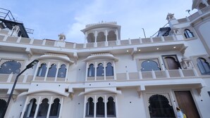 A multi-story building with ornate balconies and arched windows. - A 26 Hilltop Heaven Resort (Udaipur)