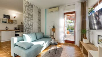 Apartamento design, 1 quarto, banheiro privativo, vista para o jardim | Área de estar | TV LCD 41 cm com canais digitais