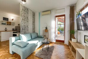 Apartamento design, 1 quarto, banheiro privativo, vista para o jardim | Área de estar | TV LCD 41 cm com canais digitais