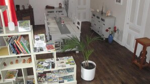 Un salon avec une bibliothèque, une table à manger, une plante en pot et une cheminée.