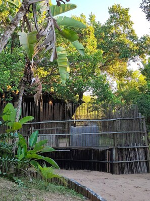 Une clôture en bois rustique, une végétation luxuriante et un ciel dégagé.