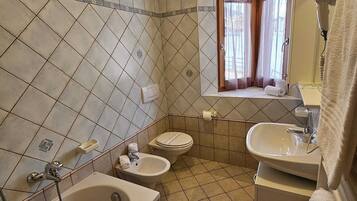A bathroom with a bathtub, two sinks, and a toilet.