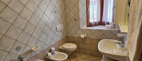 A bathroom with a bathtub, two sinks, and a toilet.