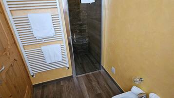 A modern bathroom with a shower, a sink, and a towel rack.