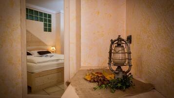 Un dormitorio con una cama, una mesita de noche con lámpara y un radiador fijado a la pared.