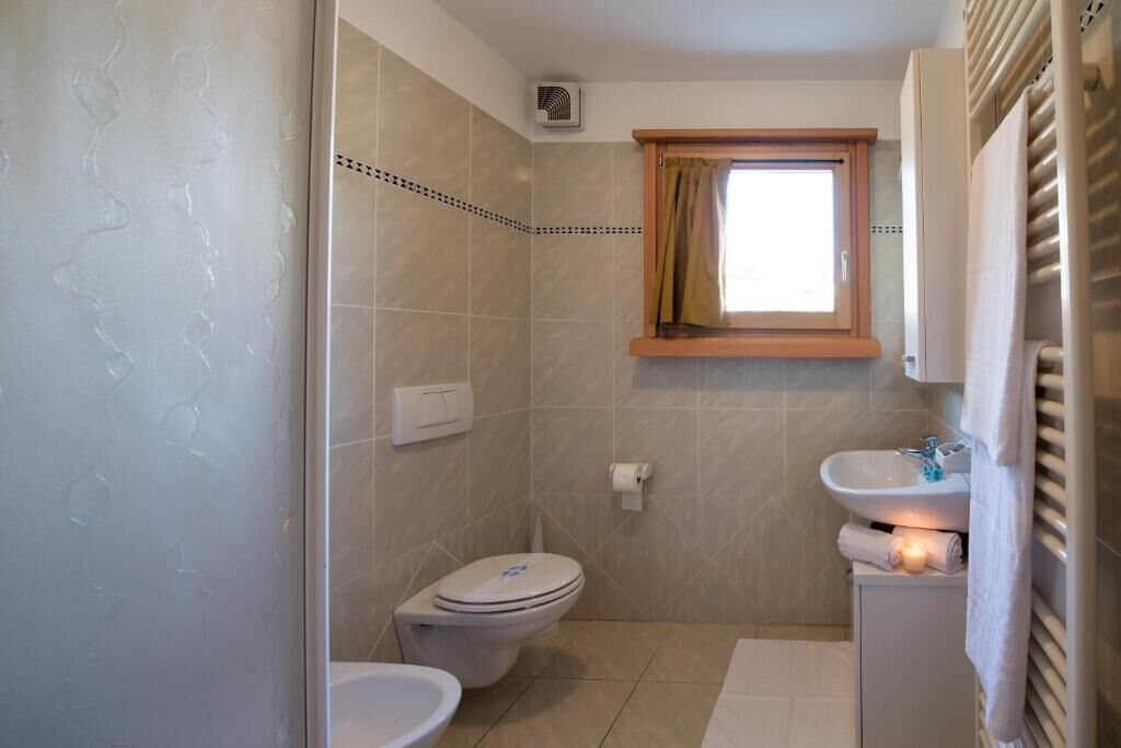 A compact bathroom with a toilet, bidet, and sink.