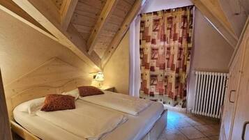 A small, cozy bedroom with a wooden ceiling and a single bed.