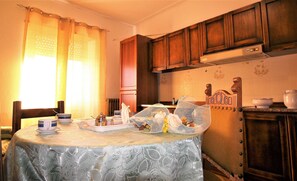 A dining area with a table set for two, featuring a lace tablecloth, a coffee set, and a decorative birdcage. - Spacious four-bedroom apartment with sea view (Santa Teresa Gallura)