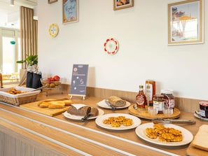 A breakfast buffet with bread, waffles, and condiments. - Aparthotel Adagio Access Paris Nanterre (Nanterre)