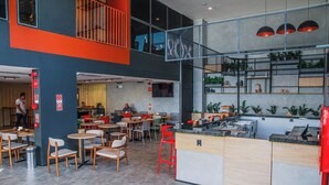 A modern restaurant with multiple seating areas, a bar, and a kitchen visible. - Ibis Araguaína (Araguaina)