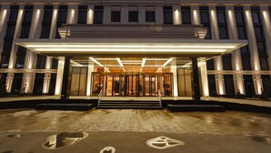 A modern hotel entrance with a covered entrance and a glass facade. - Mövenpick Tashkent Old City (Tashkent)