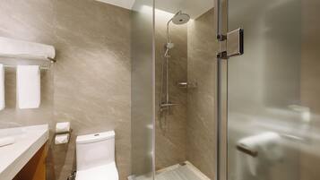 A modern bathroom with a glass-enclosed shower, a toilet, and a towel rack.