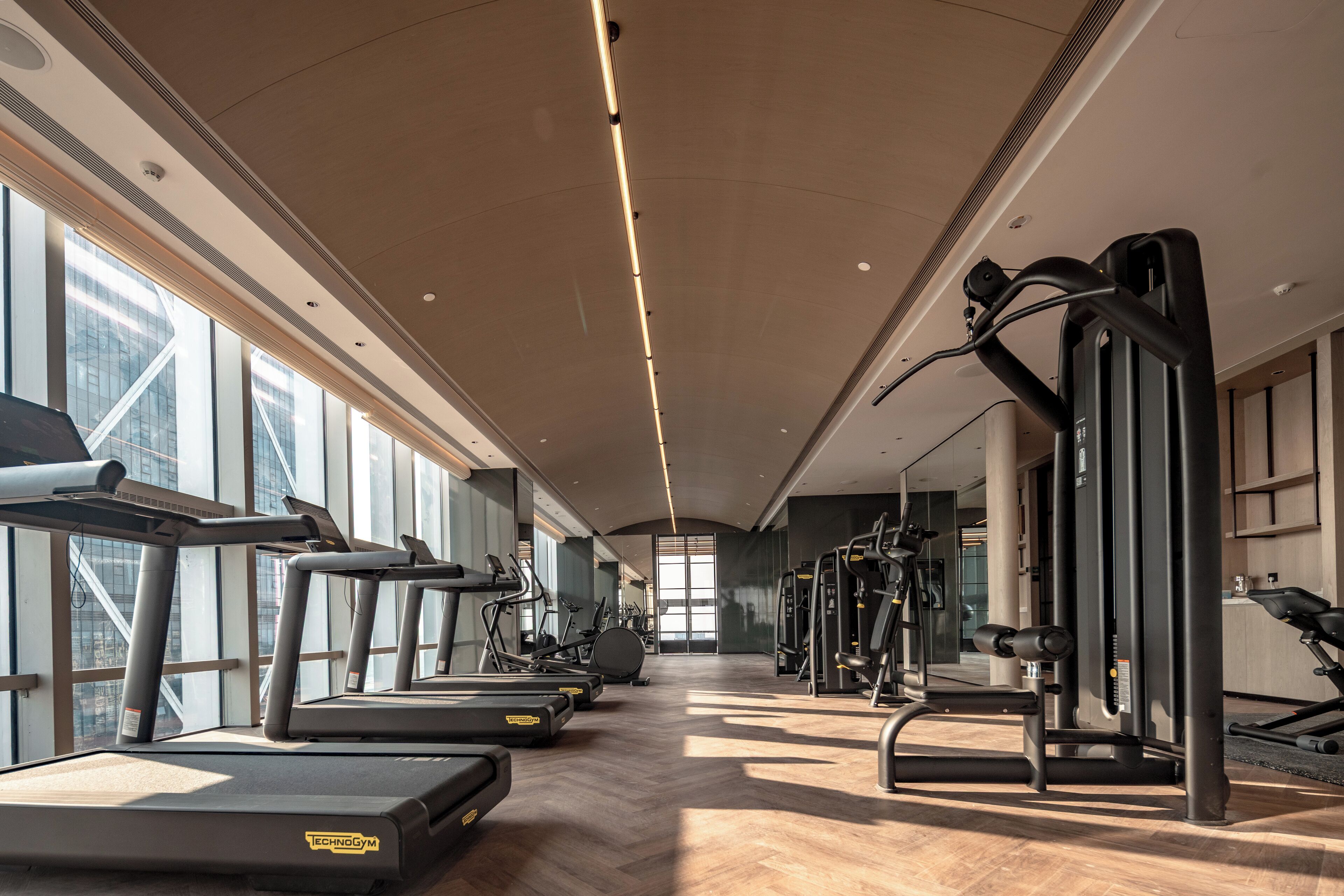 A gym with treadmills, elliptical machines, and weight equipment.