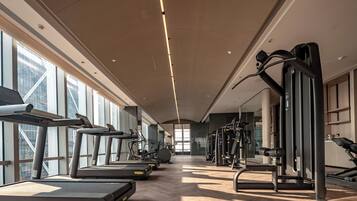 A gym with treadmills, elliptical machines, and weight equipment.
