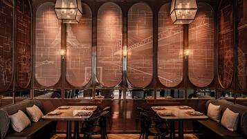 A restaurant with a long counter, booths, and a large window with a cityscape view.