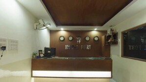 A hotel reception desk with a wooden finish and a sign that reads "HOTEL PORT". - The Turg Resort (Patna)
