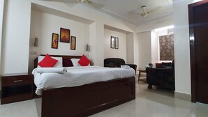 A bedroom with a bed, a desk, and a chair. - The Turg Resort (Patna)
