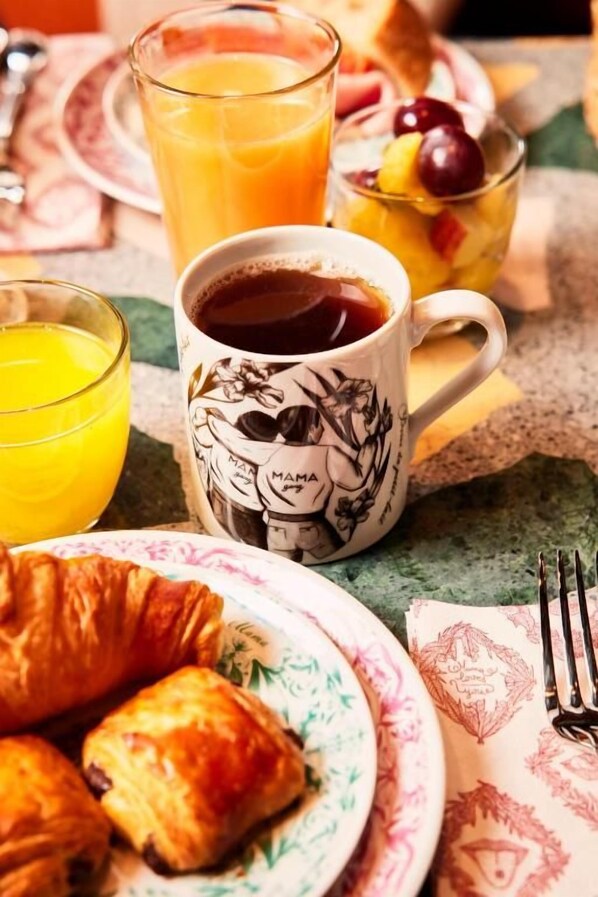 A breakfast setting with croissants, orange juice, coffee, and fruit. - Mama Shelter Mexico City (Mexico City)