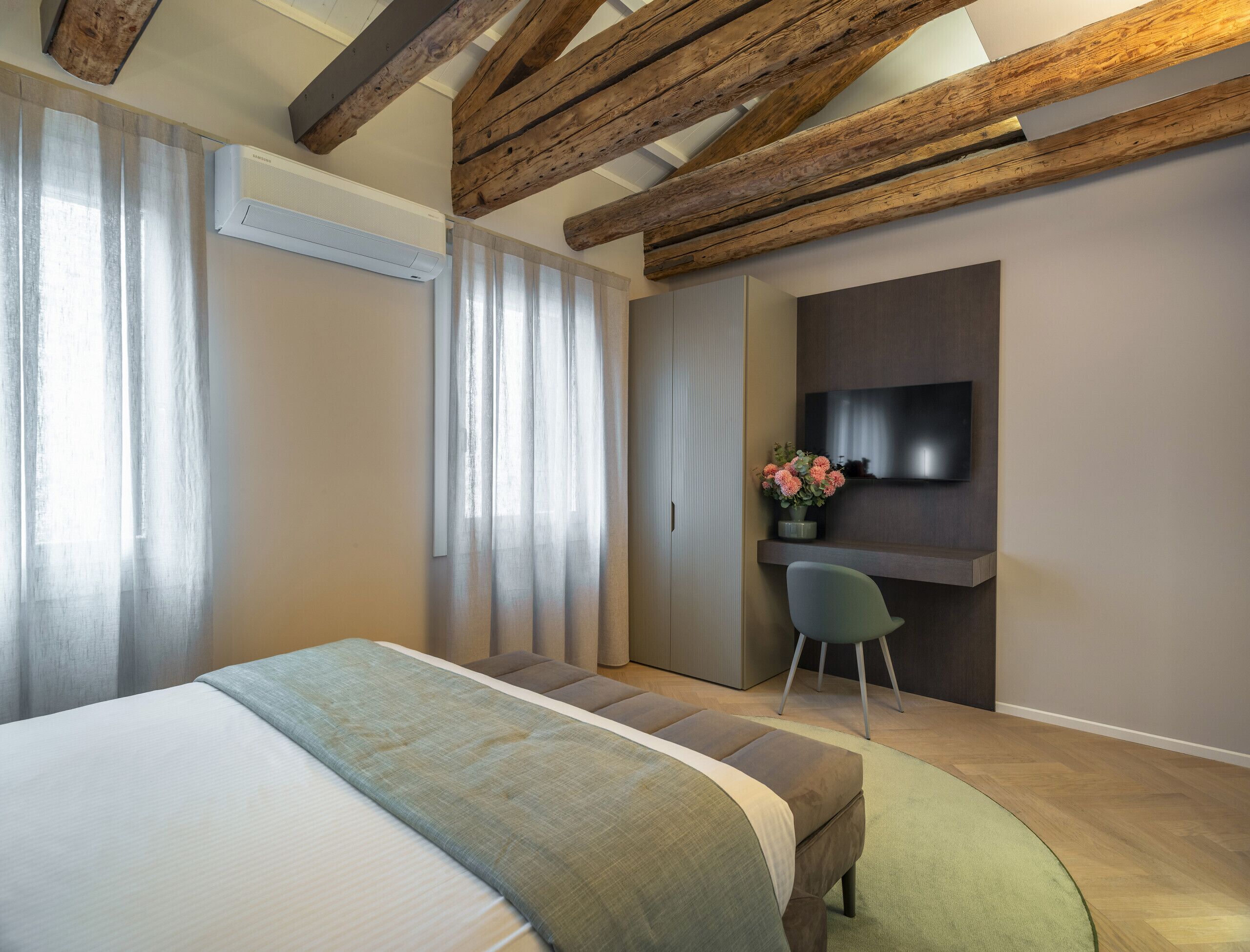 Ein modernes Schlafzimmer mit einem großen Bett, einem Schreibtisch und einem Fernseher.