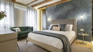 Een moderne slaapkamer met een groot bed, een groene bank en een bureau.
