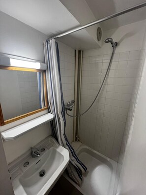 Een douche, handdoeken, zeep, toiletpapier