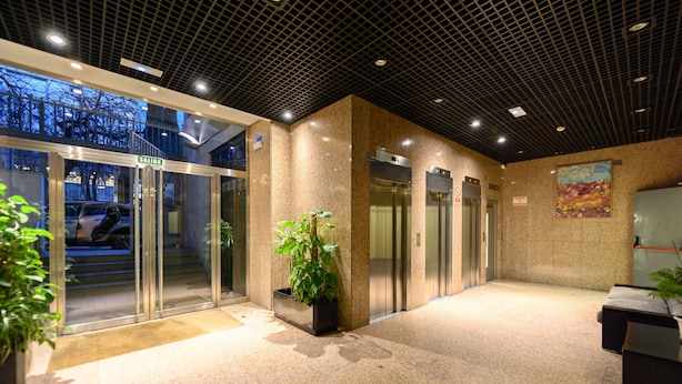 A lobby with glass doors, elevators, and potted plants. - M (ABR1710B) Spacious Luxury 2 Bedroom Apartment (Madrid)