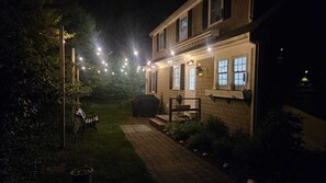 Una casa con un porche techado, luces colgantes y una parrilla de barbacoa.