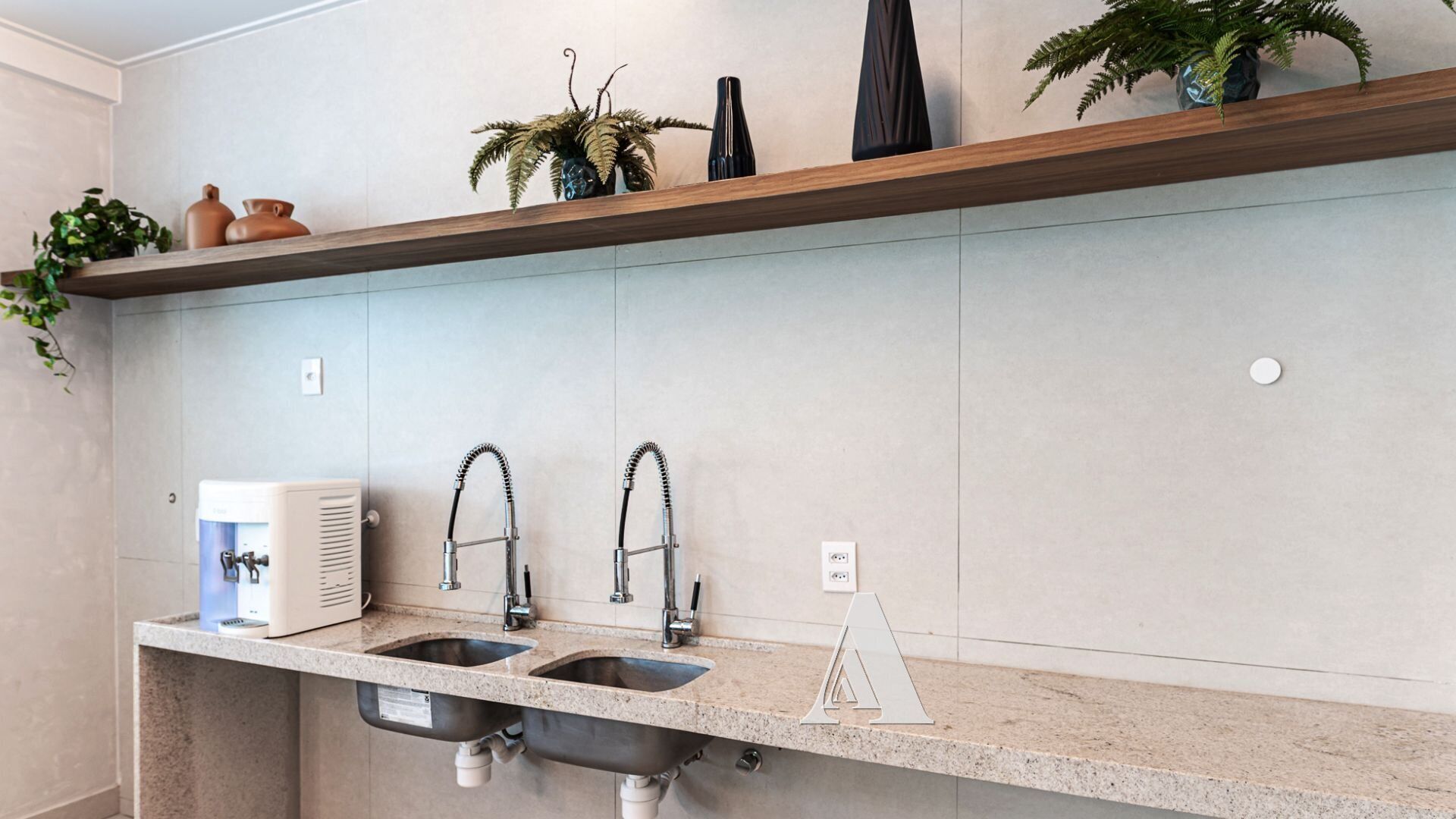 Cocina moderna con dos fregaderos, dispensador de agua empotrado y repisa de madera con objetos decorativos.