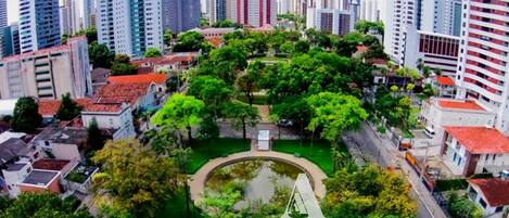 Un quartier urbain dense, caractérisé par de nombreux immeubles de grande hauteur et un parc central agrémenté d’un étang, le tout entouré de bâtiments résidentiels et commerciaux.