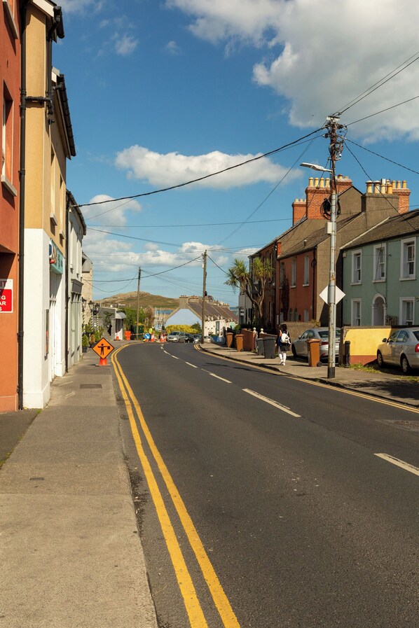 A street with buildings, a clear sky, and a pedestrian crossing sign. - Seafront Suite in Howth (Howth)