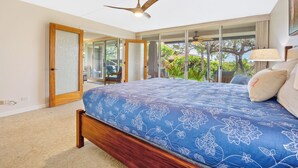 A bedroom with a large bed, a ceiling fan, and a view of the outdoors. - Walk to Beach | Beach Cabana | AC | Eldorado B102 | Ground Floor | New 1 BR (Ka'anapali)