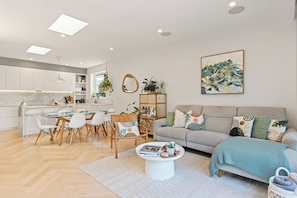 Ein modernes Wohnzimmer mit Sofa, Couchtisch und Essbereich.