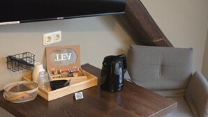 A wooden side table with a black coffee maker, a wooden tray with stationery, a wicker basket, and a sign with the letters "LEV". - Aparthotel Fairschlafen Minden (Minden)