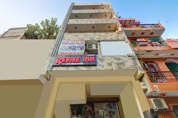Un hotel llamado "Revive Inn" con un letrero que anuncia habitaciones de lujo para parejas, privacidad y seguridad.