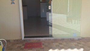 A hotel entrance with a tiled floor, a red mat with "Bem-Vindo" text, and a wall-mounted sign with a message. - Complete House in Pontal do Peró: Comfort and nature next to Búzios (Cabo Frio)