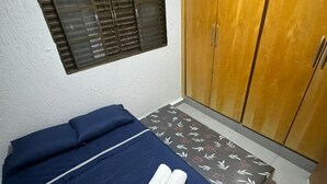 A room with a bed, a wardrobe, an air conditioner, and a window with blinds. - Cozy 2-bedroom apartment with balcony near the Shopping Mall (Uberlândia)