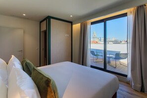 A hotel room with a bed, a large window, and a view of the cityscape. - Casa Falcão Boutique Hotel by Aspasios (Porto)