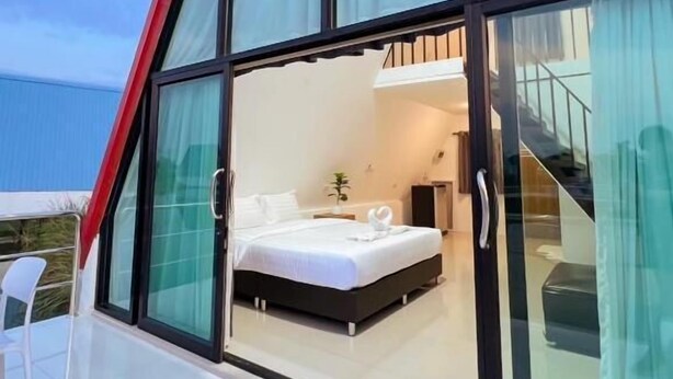 Une chambre moderne avec un grand lit, une petite table de chevet et une fenêtre avec des rideaux.