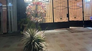 Una entrada protegida por un portón decorativo y un cartel que indica el número 4 de 4.