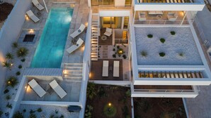 Une maison moderne à plusieurs niveaux, dotée d’une piscine, d’espaces de détente en plein air et d’un jardin bien entretenu.