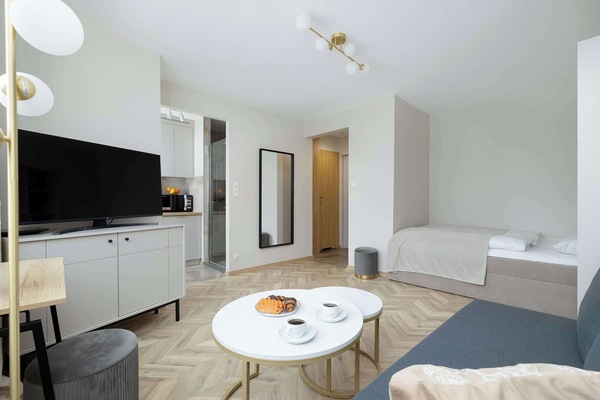 A comfortable living area with a sofa and a wall-mounted TV. The space is perfect for relaxing and watching your favorite shows.
