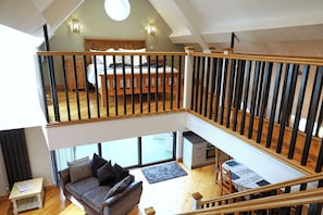 A multi-level living space with a loft bedroom, a dining area, and a seating area with a view. - Bathway Farm (Radstock)