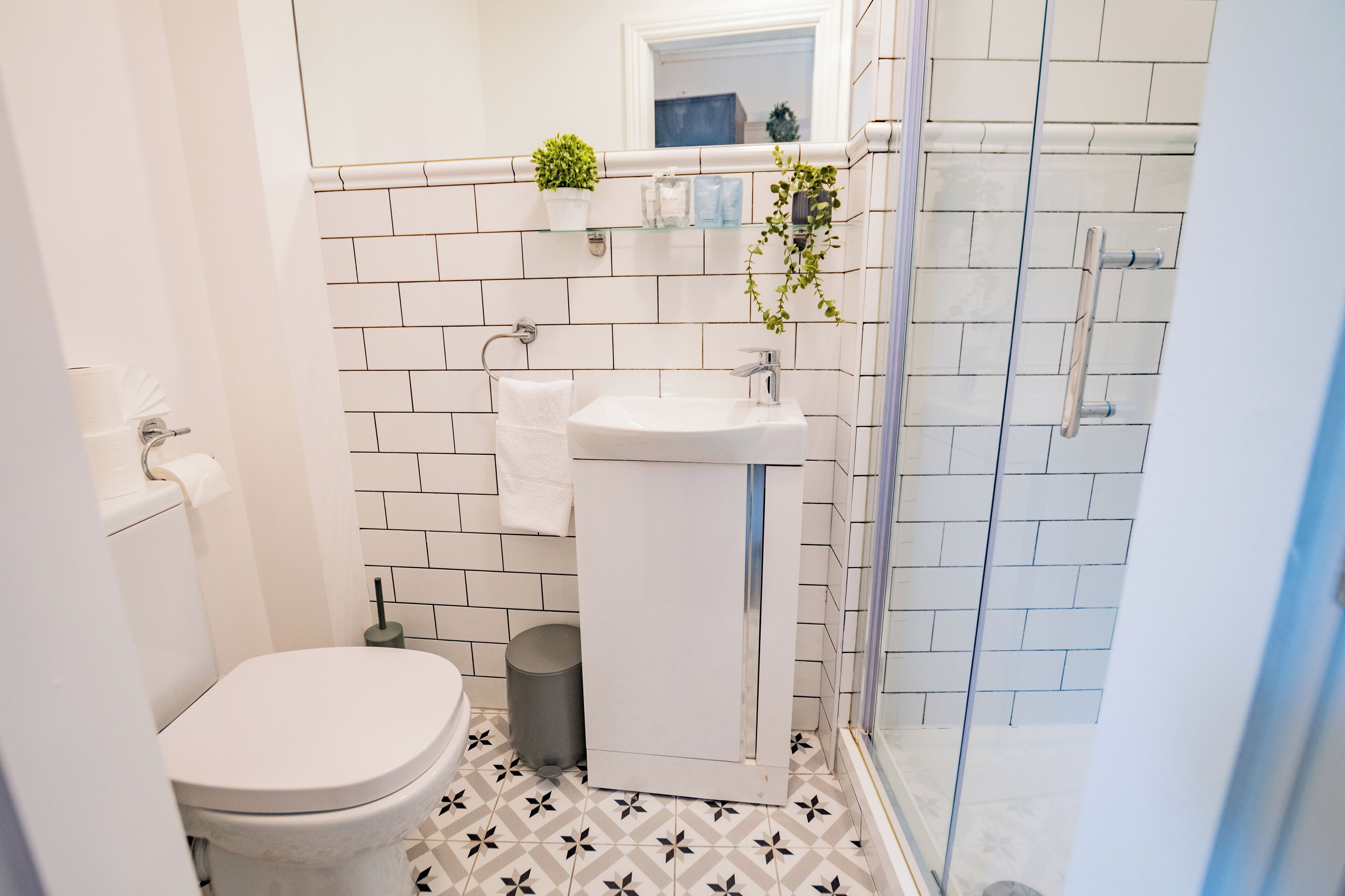 A bathroom with a toilet, sink, and shower.