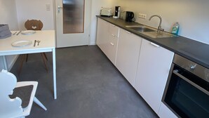A modern kitchen with white cabinetry, a countertop, a sink, a coffee maker, and a toaster. - Apartment 'Lichtblick unter der Buche' with Terrace, Great Views and Wi-Fi (Titisee-Neustadt)