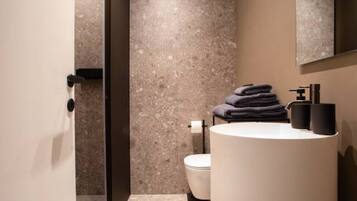 Un bagno moderno con un lavabo rotondo, un water e un porta asciugamani.