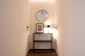 A hallway with a framed picture on a console table, a round mirror on the wall, and a floor lamp. - Villa Sull'acqua - Lakefront/Modern/AC/Parking (Laglio)