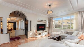 Una sala de estar moderna con un televisor grande, un sofá y una mesa de centro.